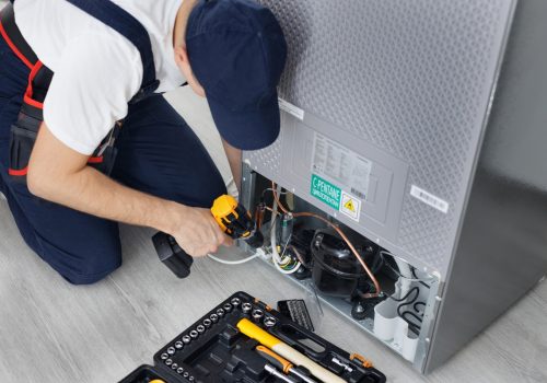 male-technician-repairs-a-refrigerator-in-the-kitchen-in-close-up-.jpg